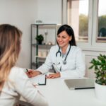 O que é gastroenterologia: médica sorrindo conversando com paciente.