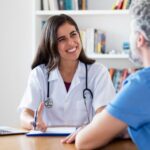 Médica explicando para paciente quanto tempo dura a sedação da endoscopia.