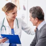 Manometria anorretal: médica conversando com paciente.